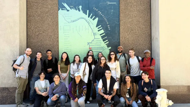 Group of students standing in front of a tall map of a San Francisco pier