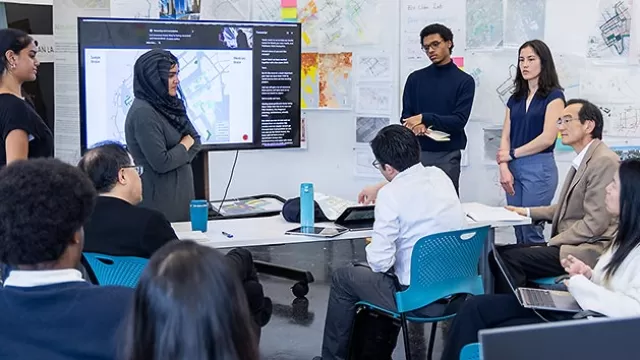 Image from one of Georgia Tech's capstone studios with students sitting and standing for a presentation