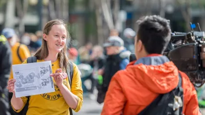 Current Seattle mayor-elect Katie Wilson holding up a sign during a transit protest.