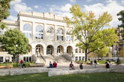 People sitting and walking in plaza in front of historic Benton County Courthouse in Bentonville, Arkansas.