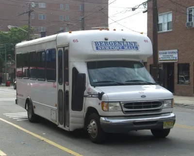 White 'dollar van' commuter transit minibus in New York City.