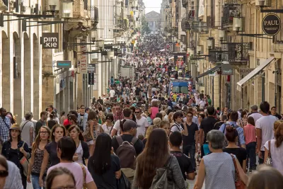 The Rue Sainte-Catherine in Bordeaux is crowded with pedestrians in a lively European scene.