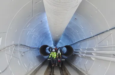 Two workers inside white Boring Company tunnel in Hawthorne, California.