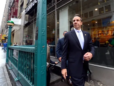 Former New York Governor Andrew Cuomo walking down city street.