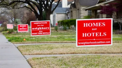Red and white "homes not hotels" signs in front yards in Dallas, Texas.