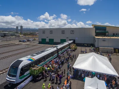 A crowd of people around one of Honolulu's automated trains.
