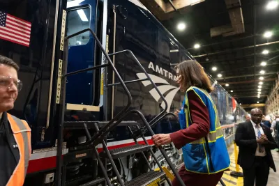 New York Governor Kathy Hochul climbing onto Amtrak train.