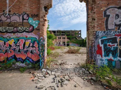 Ruined brick walls with graffiti on them stand as part of partically demolished building in Clevelannd, Ohio.