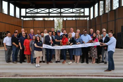 A crowd of people cut the ribbon on Fresco's new downtown.