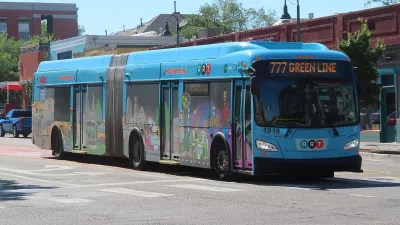 Colorful ABQ RIDE public transit bus in Albuquerque, New Mexico with low-rise brick buildings in background.
