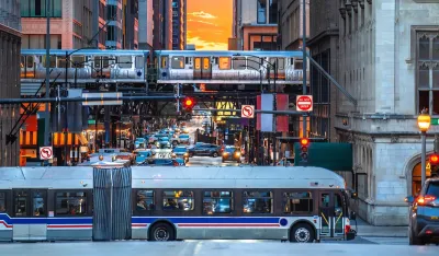 White CTA bus and elevated train against sunset sky in downtown Chicago, Illinois.