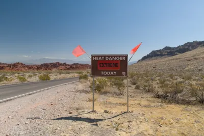 "Heat Danger Extreme Today" sign on desert roadside with orange flags on either side.