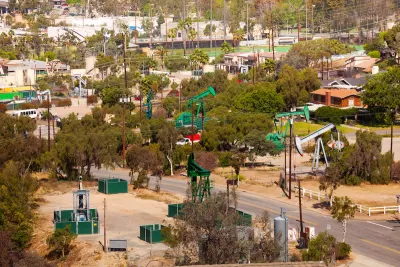 View of green oil wells in a residential neighborhood in California.