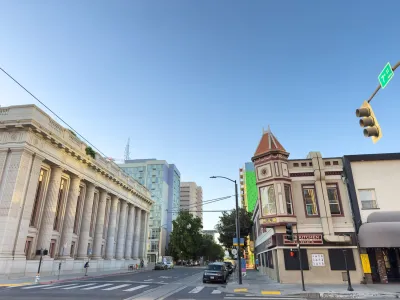 Intersection in downtown Sacramento, California with neoclassical building with columns on left.