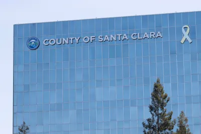 Flat modern glass office tower with "County of Santa Clara" sign.