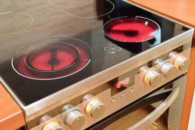 Close-up of electric stove range with front burners red-hot.