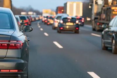 Close-up of rear car bumper in traffic on freeway.