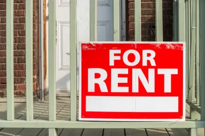 Close-up of red For Rent sign with white text on porck of brick building.