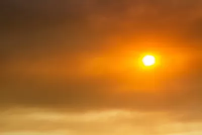 Sun seen through red wildfire sky and smoke.