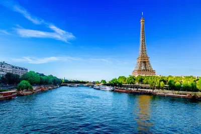 View from middle of River Seine in Paris with Eiffel Tower on right side.