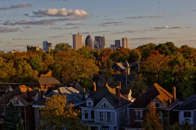 View of homes nestled among green trees with Columbus, Ohio skyline in background
