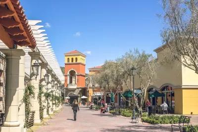 Suburban outdoor mall in muted colors with decorative tower.