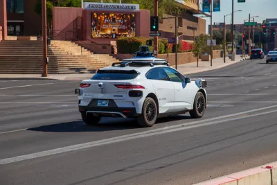 White Waymo self-driving vehicle in front of Phoenix Convention Center.