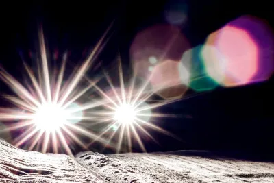 Bright car headlights with glare at night.