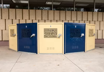 Blue and beige secure bike lockers in underground passageway etched with bicycle logo