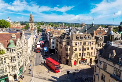 Aerial view of historic Oxford, England street with old buildings and red double-decker bus
