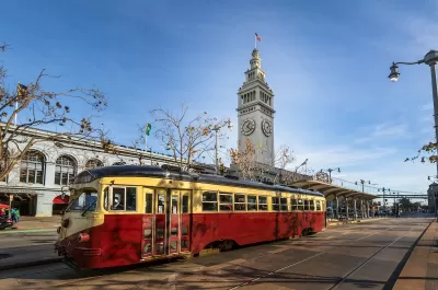 Red and yellow vintage streetcar in front of San Francisco Ferry Building.
