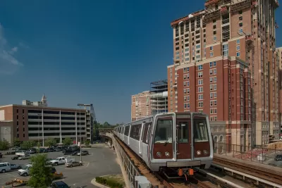 WMATA train on elevated track passing by brick multistory buildings in Alexandria, Virginia.