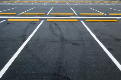 Empty asphalt parking lot with white lines.