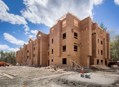 Wood-framed four-story building under construction.