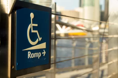 Close-up of blue and white wheelchair ramp sign with arrow pointing right.