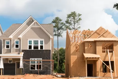Two wood-frame houses under construction.