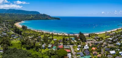 Aerial view of coastal development and bright blue ocean in Kaua'i, Hawai'i.
