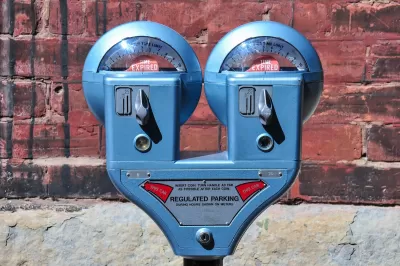 Close-up of old-fashioned blue double parking meter against red brick wall.