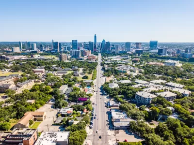 Aerial view of downtown Austin, Texas with state capitol dome at end of long, straight boulevard.