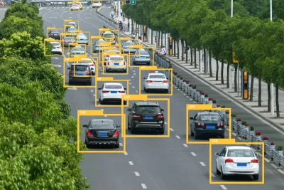 View of traffic on a multilane highway with superimposed yellow triangles identifying vehicles.