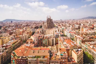 Aerial view of Barcelona, Spain with Sagrada Familia church in middle among dense buildings.