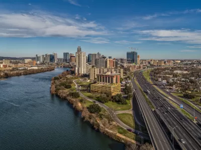 Austin skyline at dusk with a river on the left and I-35 running along the right.
