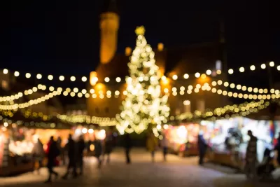 Blurred image of Christmas lights at nighttime draped over Christmas market in Tallin, Estonia.
