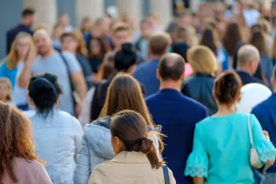 Blurred dense crowd of people with no recognizable faces walking in a busy city.