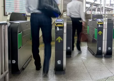People entering modern fare gates in subway station.