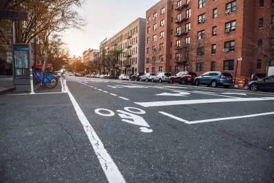 Low view of bike lane on New York City street with bike share station next to curb.