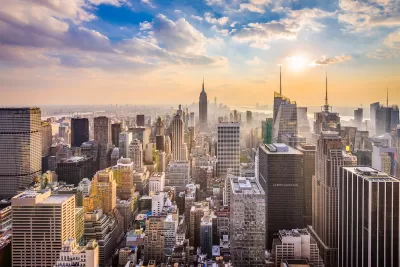 New York City skyline with Empire State Building in center and blue cloudy sky.