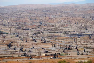 View of vast oil drilling field with black oil derricks near Bakersfield, California