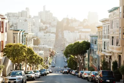 View down San Francisco street downhill with cars parked on both sides.