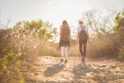 Two young women hiking at golden hour.